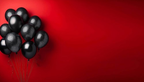 A cluster of black balloons floats against a bold red background, representing celebration, party,