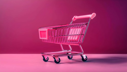 A bright pink shopping cart sits on a magenta background, symbolizing online shopping and