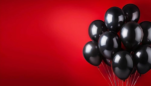 A group of shiny black balloons against a vibrant red background, creating a bold and festive