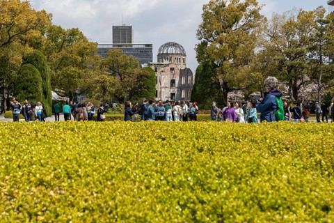 Tourists in the Peace Park with a view of the ruins of the Atomic Bomb Dome, landmark, UNESCO World