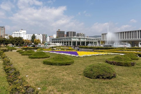 Colourful flower beds and fountains in front of the Hiroshima Peace Museum, tourist attraction,