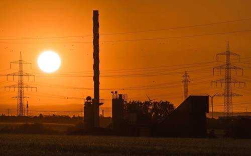 Sunrise behind an asphalt mixing plant. Niederursel, Frankfurt am Main, Hesse, Germany