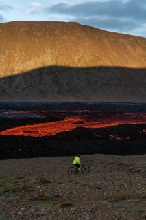 Mountain biking next to flowing lava and an active volcano. Fagradalsfjall, Reykjanes, Iceland