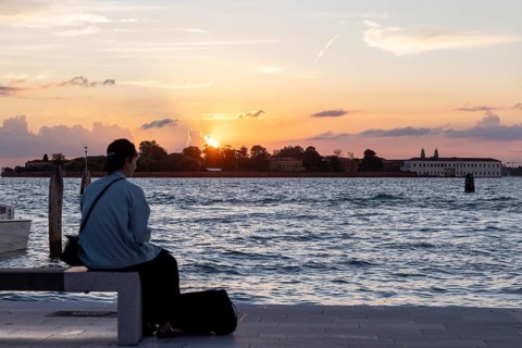 Venice, Italy - 2 September 2025: Passengers sit on the jetty at the Lido at sunset, waiting for