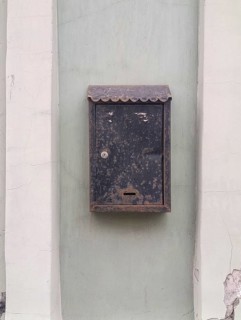 Old metal mailbox hanging on the wall of the house, copy space