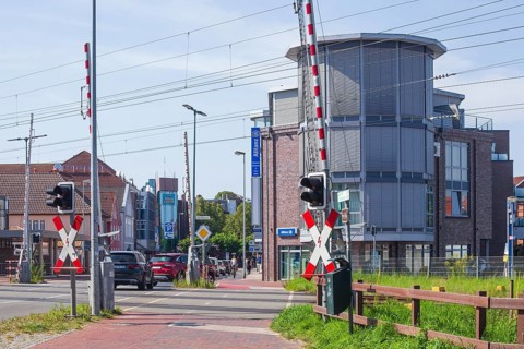 Gated railway crossing with houses, Leer, East Frisia, Lower Saxony, Germany