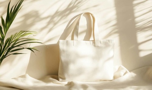 A cream-colored canvas bag placed in soft sunlight with shadows from a plant. AI generated