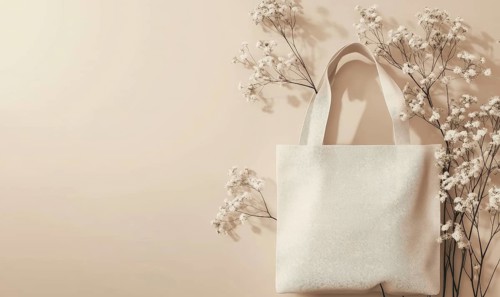 A white tote bag surrounded by delicate white flowers against a soft beige background. AI generated