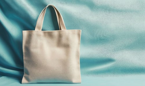 A white bag is on a blue background. The bag is open and the handle is visible. The bag is placed