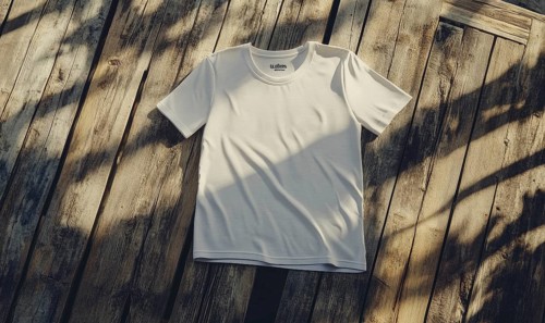 A white shirt is laying on a wooden surface. The shirt is unbuttoned and has a collar. The shirt is