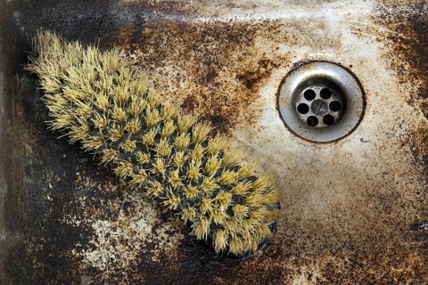 Detail shot of a old dirty sink with scrubber inside