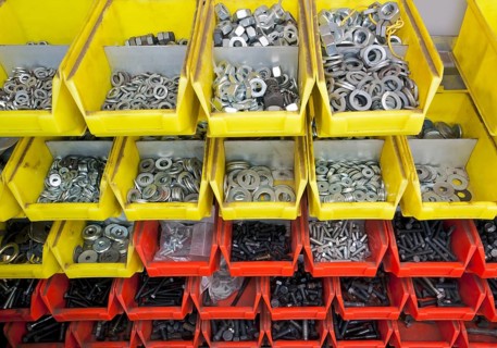 Full frame industrial background showing yellow and red boxes filled with lots of various screws