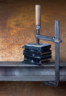 Some hard disk drives compressed with a screw clampin rusty back