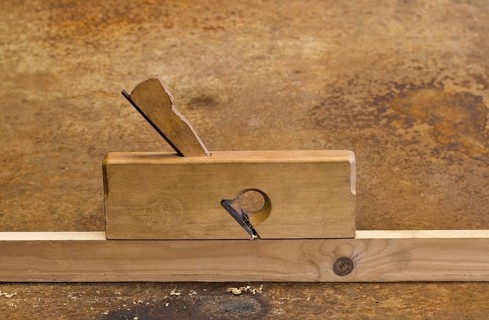 Old planer on wooden plank