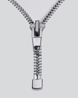 Studio photography of a long zipper half closed, in light back