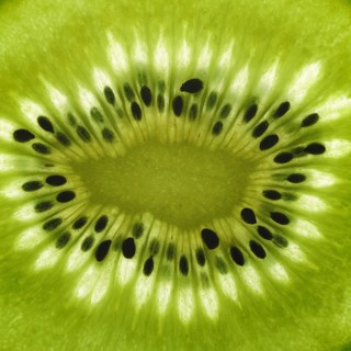 Full frame detail of a thin translucent sliced kiwifruit