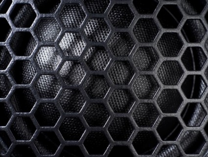 Full frame black grid of a speaker detail in dark back