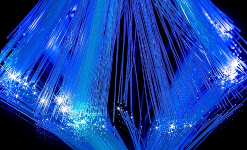 Blue illuminated optical fiber closeup in black back