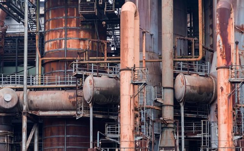 Weathered rusty industrial scenery with old corroded steel girders and metal tubes