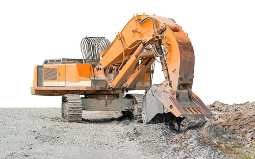 Huge orange colored tracked excavator partly isolated on stony ground