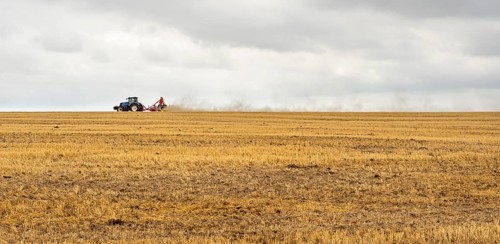 Stormy farmland scenery showing a Tractor on a stubble field in Hohenlohe, an area in Southern