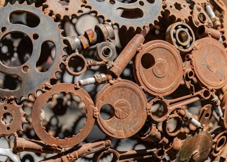 Closeup shot of a rusty sculpture welded of various metal pieces in sunny ambiance