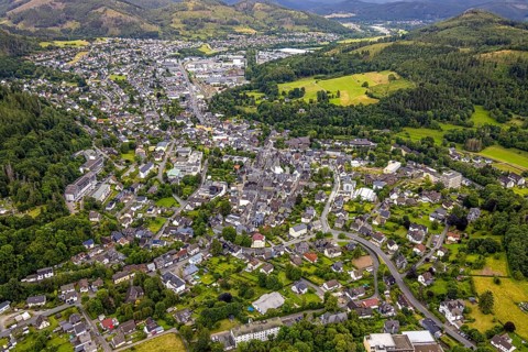 Aerial view, residential area local view, surrounded by hilly forest landscape with forest damage,