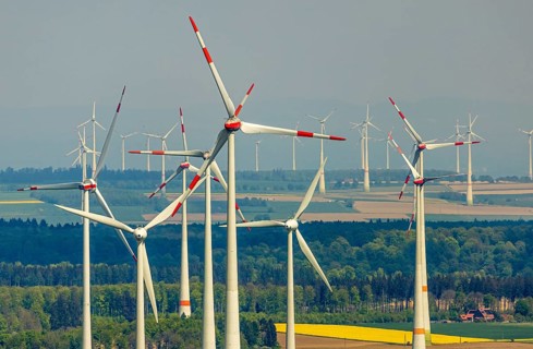 Aerial view, wind park and wind farm wind energy plant, wind turbines and rape fields near