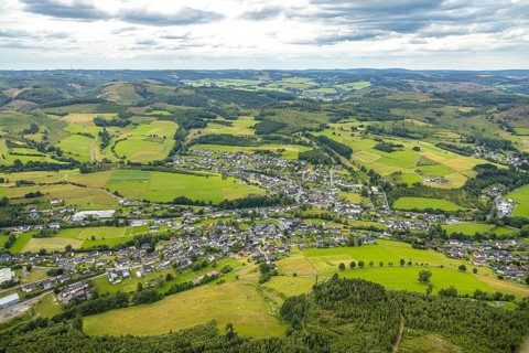 Aerial view, local view residential area Banfe, wooded hilly landscape, distant view and blue sky