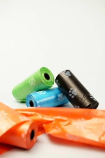 Rolls of biodegradable dog poop bags showing paw prints, promoting responsible pet ownership and