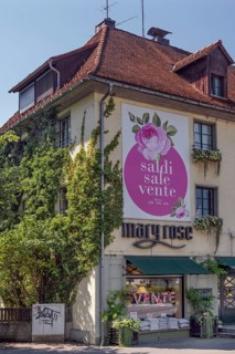 Overgrown façade with floral decorations and advertising poster, Dornbirn, Vorarlberg, Austria