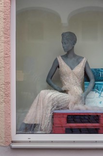 Shop window with grey fashion mannequin in evening dress, Bavaria, Germany