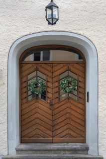 Façade with wooden gate, lantern and ivy wreaths, Kempten, Allgäu, Bavaria, Germany