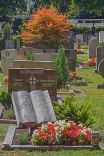 Gravesite with stone book and floral decoration, catholic cemetery, Kempten, Allgäu, Bavaria,