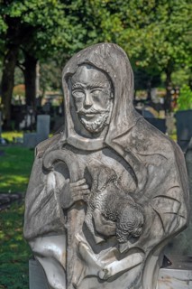 Gravesite with stone figure, the good shepherd with lamb catholic cemetery, Kempten, Allgäu,
