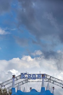 Circus tent, circus tent with luminous lettering in front of a blue sky with white and grey clouds,