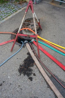 Water hoses and warning triangle on tarmac above open gully, Circus-Krone, Kempten, Allgäu,