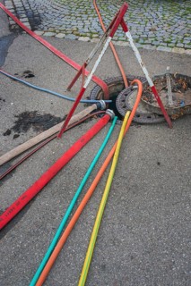 Water hoses and warning triangle on tarmac above open gully, Circus-Krone, Kempten, Allgäu,