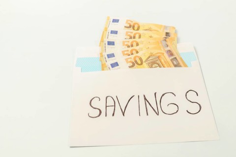 Euro banknotes in an envelope labeled savings illustrating the concept of personal finance and