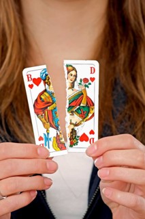 Woman holding a torn playing card in her hand