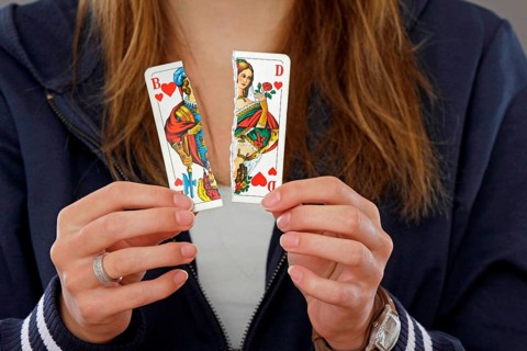 Woman holding a torn playing card in her hand