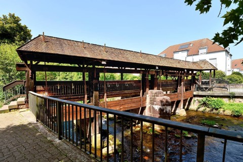Ettlingen, Germany - August 13th 2025: Old wooden bridge over the Alb river. Historic landmark on a