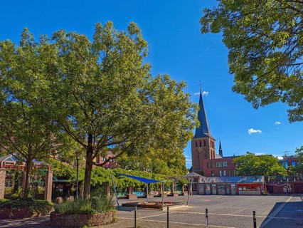 Old town with catholic church St. Margareta, brick building, architecture, square with sandpit,