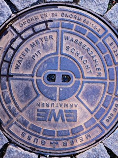 Cover of a water meter pit, water meter pit, city centre, street, round cast iron shape, standard,