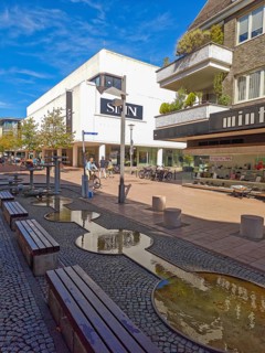 Pedestrian zone with fountain, department stores', pedestrians, traffic-calmed, young trees,