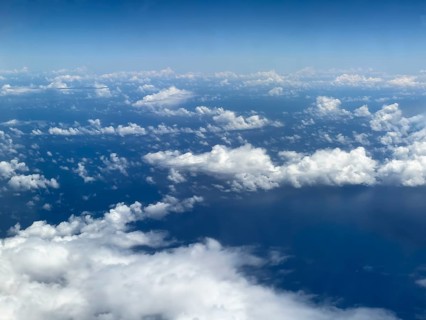 Aerial view from aeroplane at high altitude of white, bright cluster clouds Altocumulus,