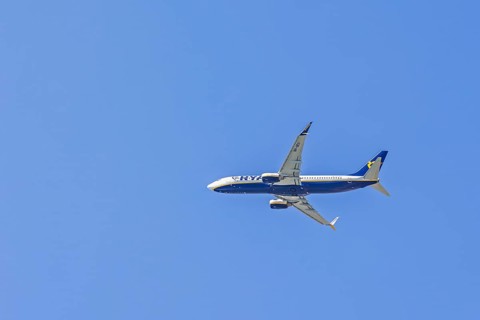 Ryanair passenger plane flying on the blue sky
