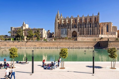 View at Palma cathedral and people by the water pond in the Parque del mar, Palma de Mallorca,