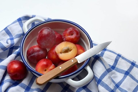Red plums in skin on cloth, Prunus domestica