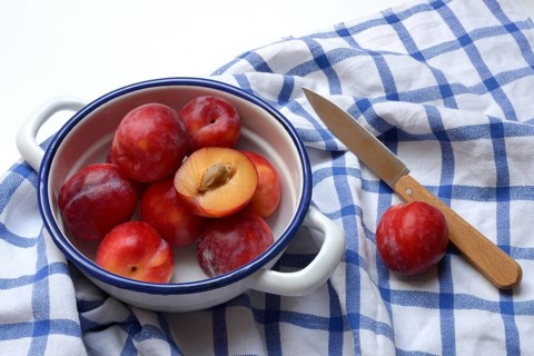 Red plums in skin on cloth, Prunus domestica